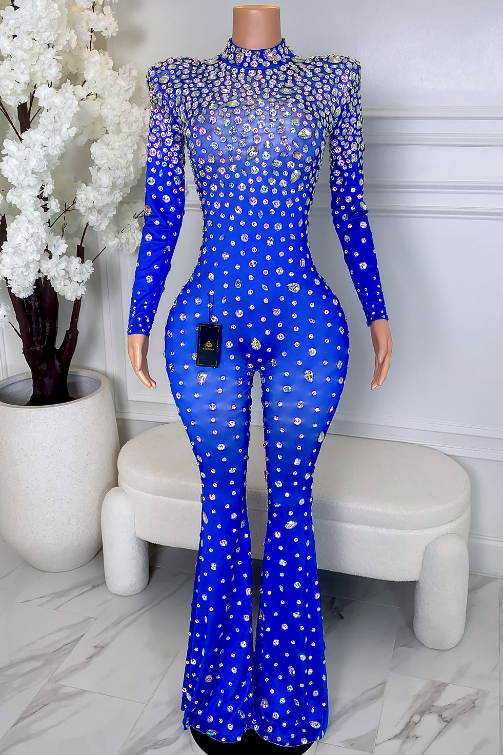 Front view of MILAN blue rhinestone jumpsuit with high neckline, long sleeves, padded shoulders, silver and iridescent rhinestones, and flared legs