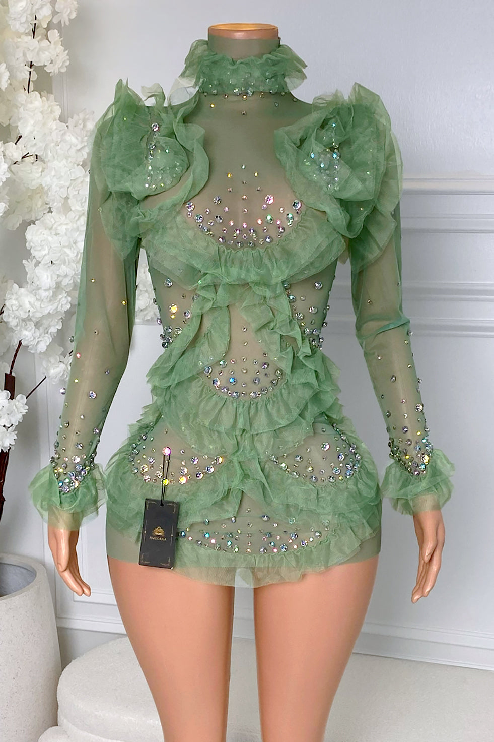 Front view of green ruffle rhinestone mini dress with sheer mesh, high neckline, long sheer sleeves, layered ruffle details, and body-hugging fit