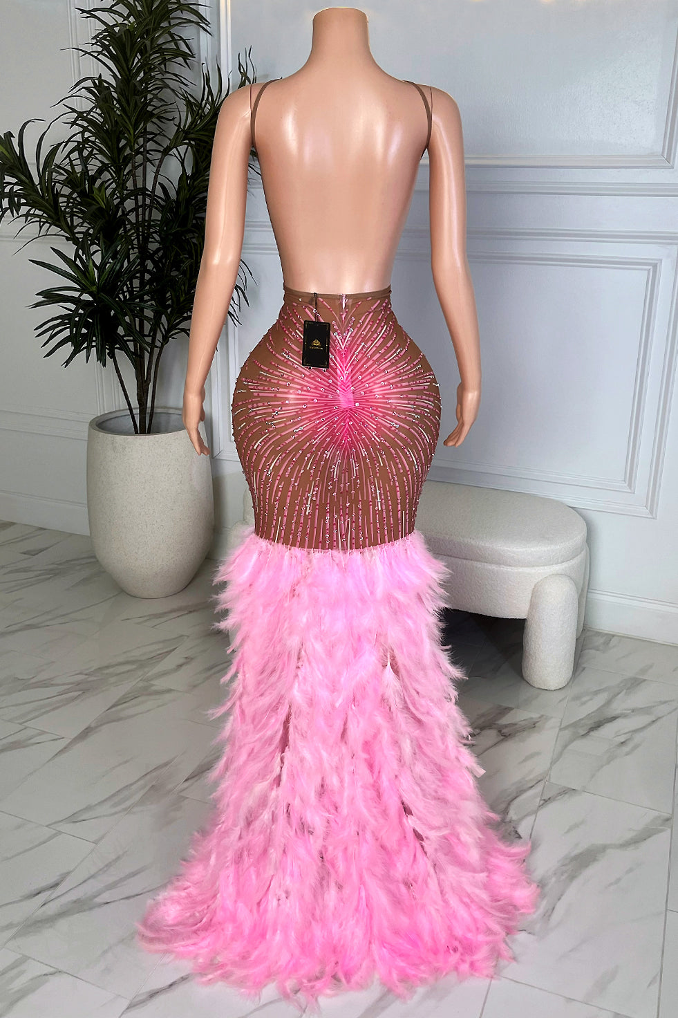 Back view of Amara Pink Feather Maxi Dress showing low back, nude mesh with pink rhinestones, and full feather train