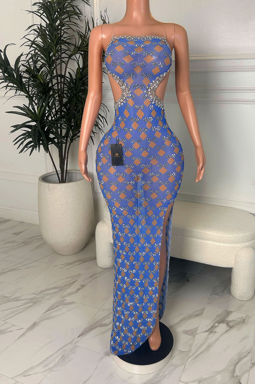 Strapless blue bodycon maxi dress with rhinestone trim, waist cutouts, geometric pattern, and high slit, displayed on a mannequin