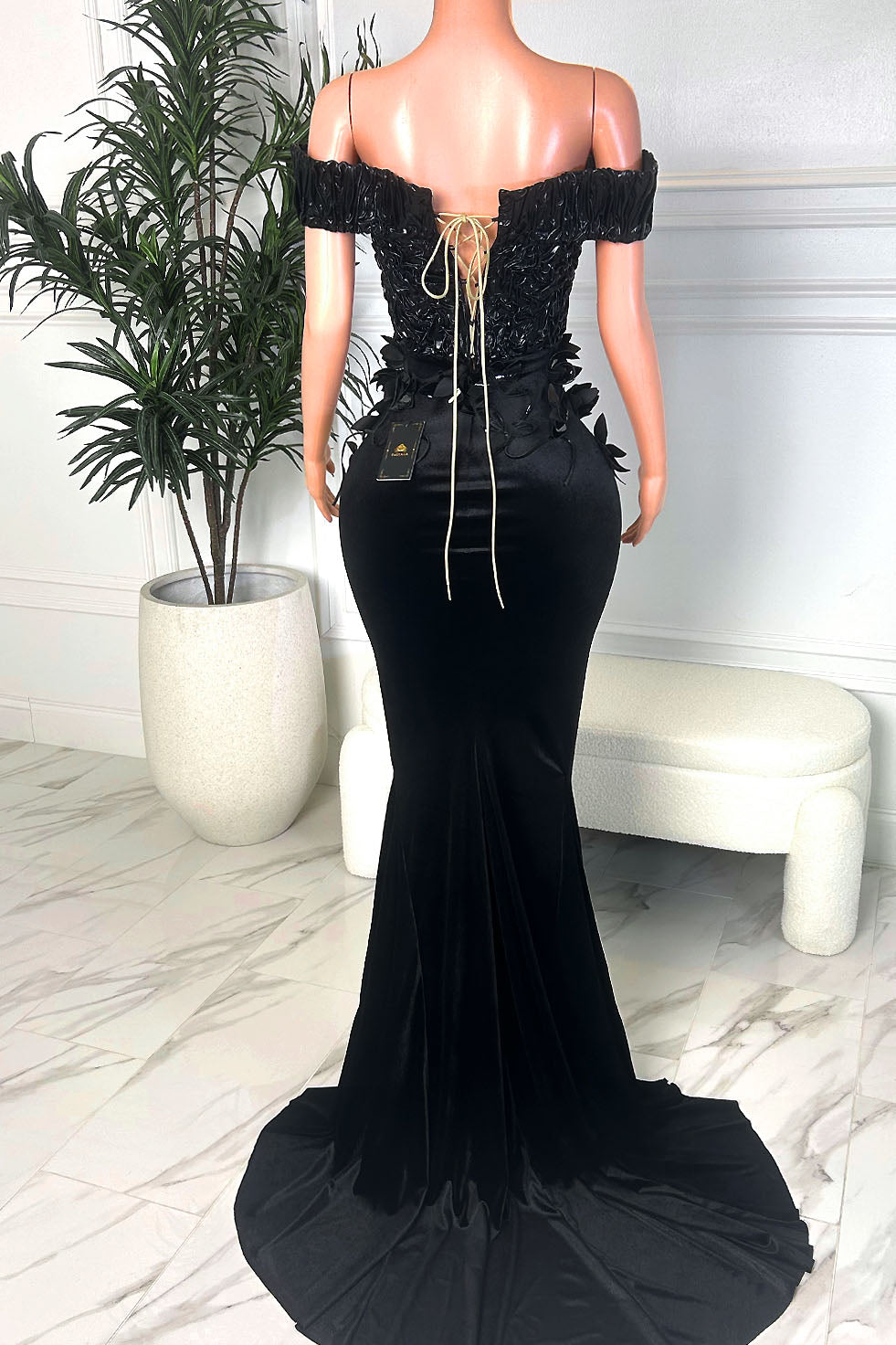 Amekana black velvet off-shoulder mermaid gown featuring couture floral appliqué at the waist and a dramatic floor-length train