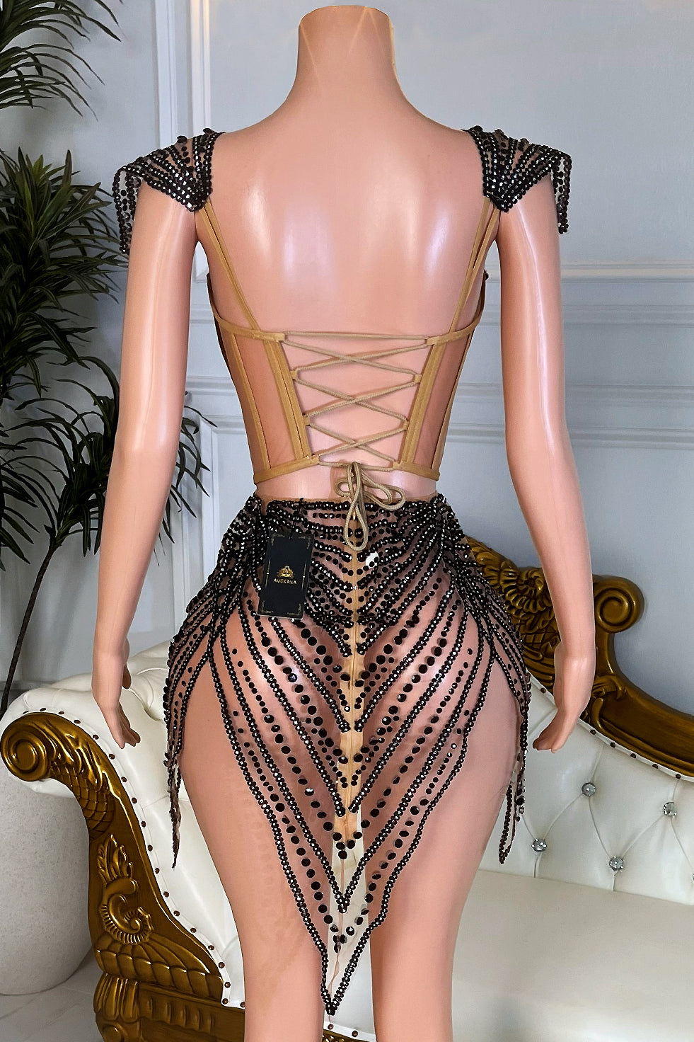 Back view of lace up nude corset mini dress with black rhinestone beading