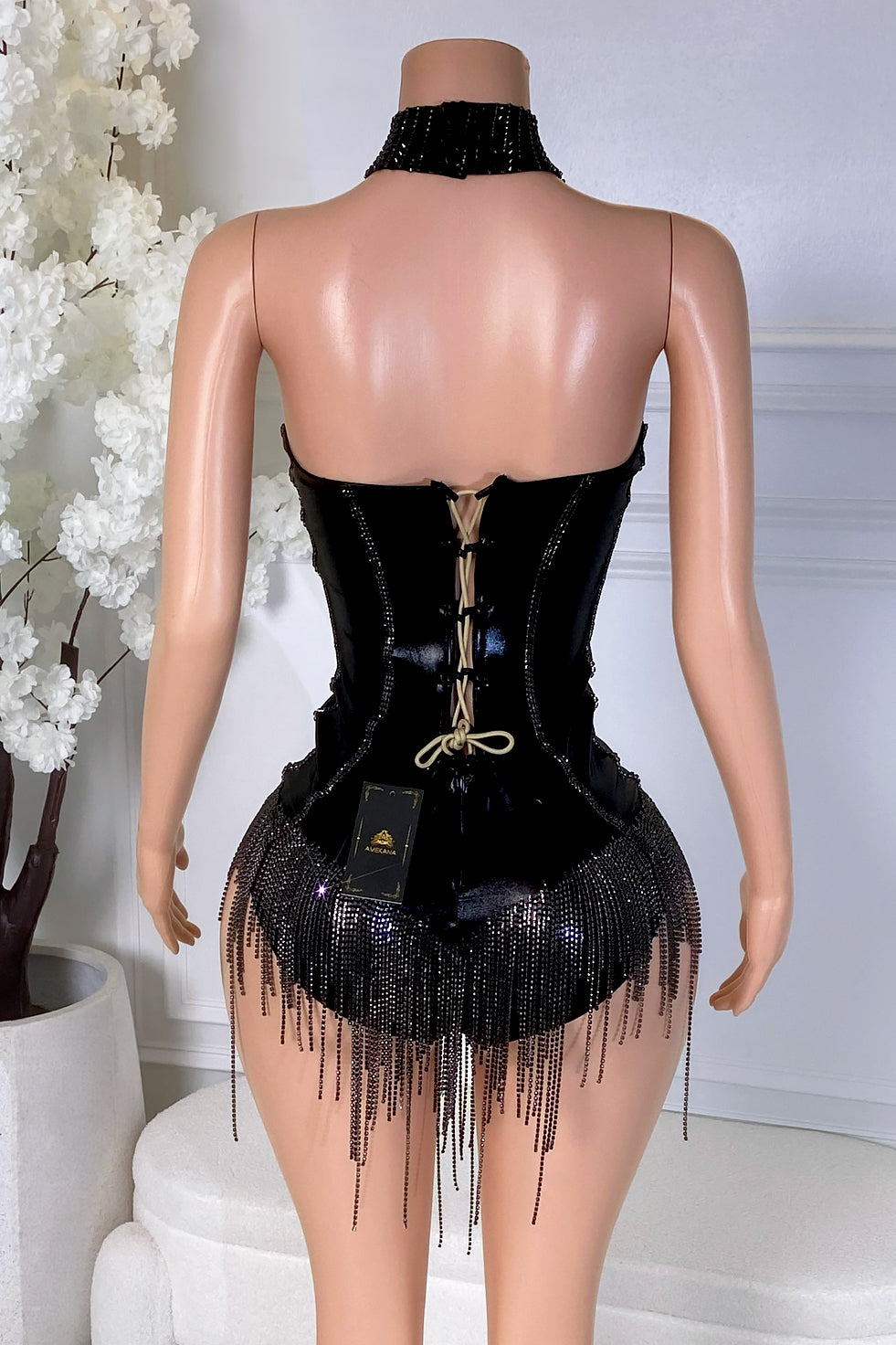 Back view of black rhinestone fringe bodysuit with lace-up closure, open back, matching choker, and beaded fringe hem