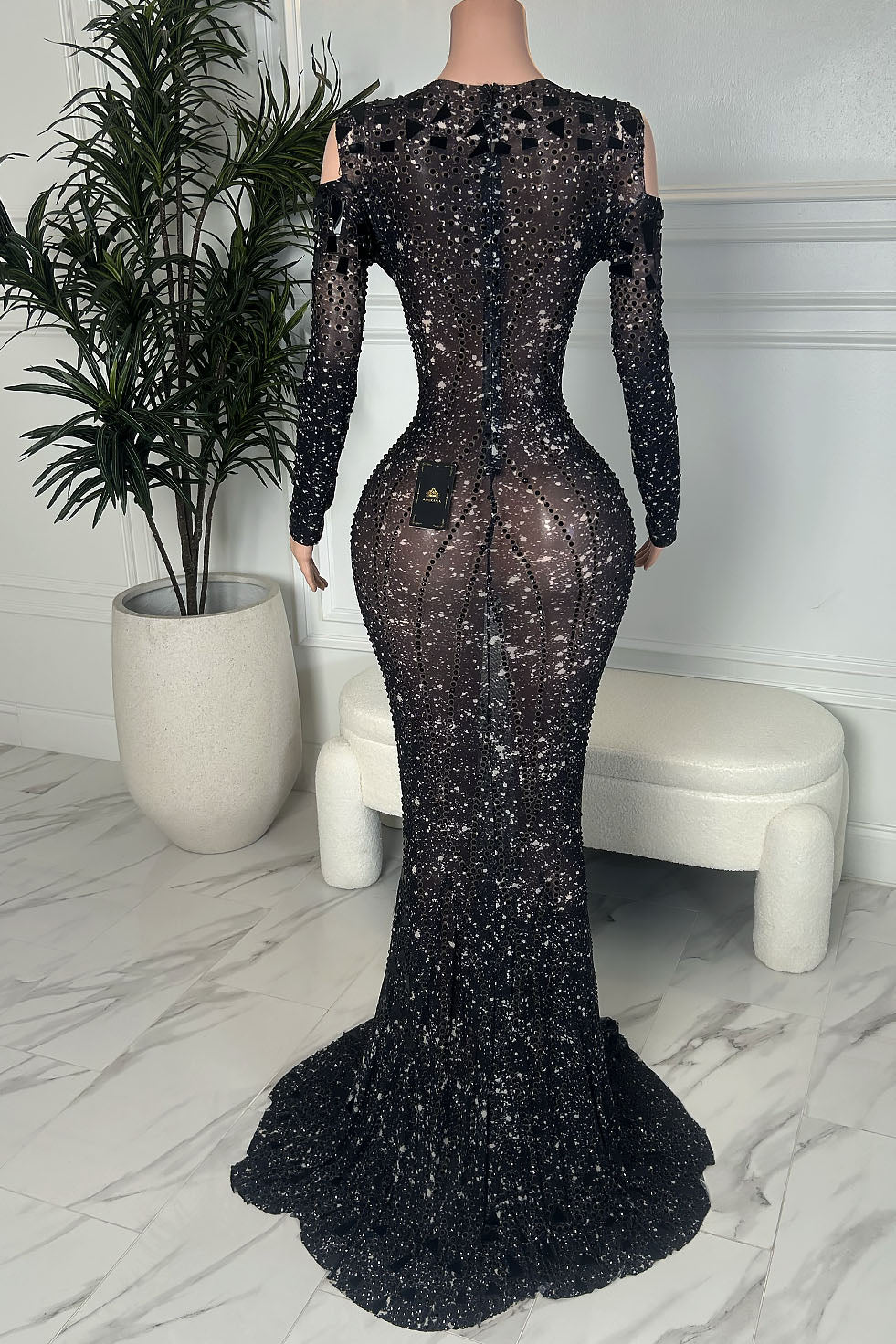 Back view of black illusion mermaid gown with long sleeves and scattered rhinestones, fitted silhouette with a flowing train