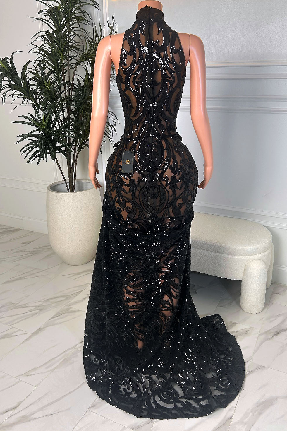 Back view of black sequin lace halter mermaid gown showing ornate lace pattern, fitted silhouette, and sweeping train