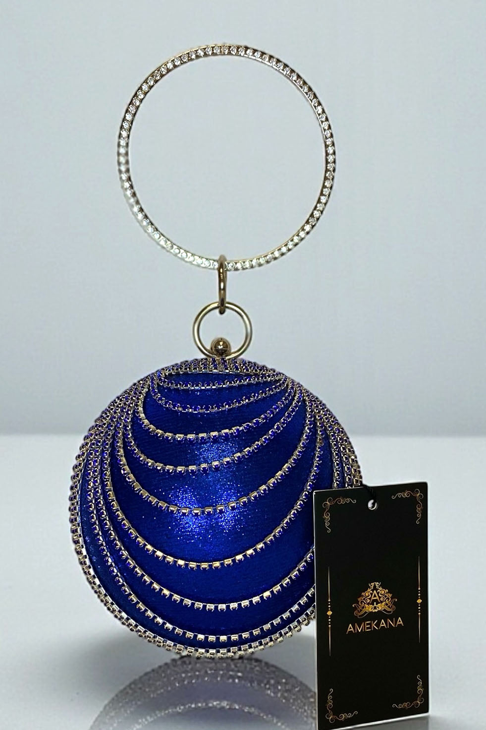 Royal blue globe clutch with draped rhinestone chains and crystal trim close-up front view on white surface