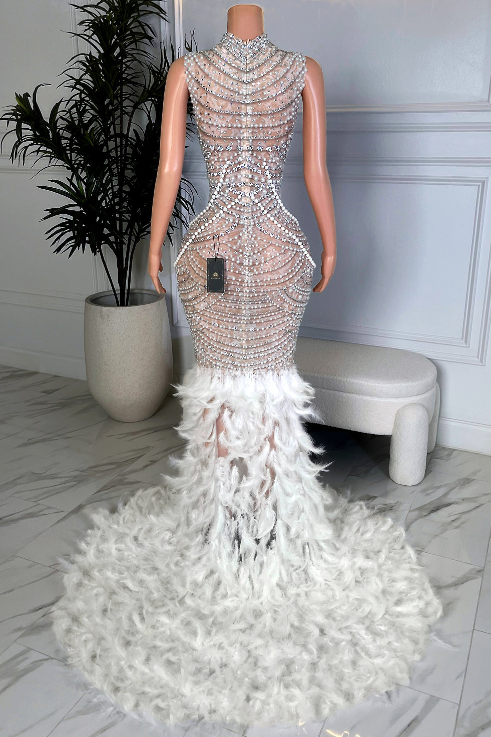 Back view of white pearl and rhinestone mermaid gown with layered pearl draping and full feather train by Amekana.