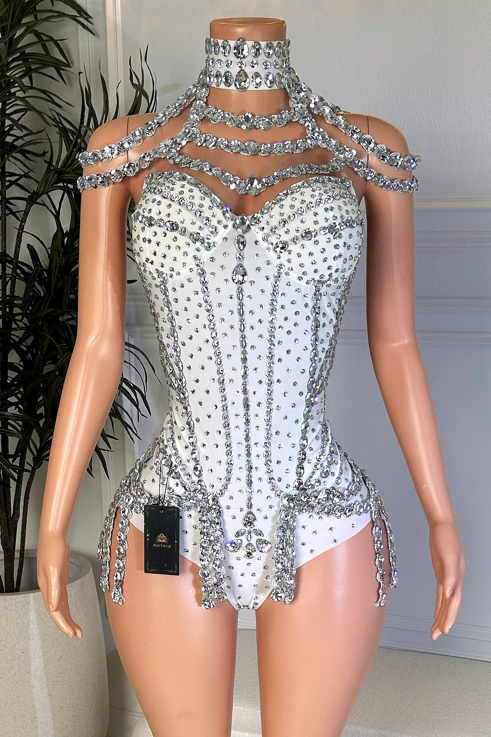 Front view of a white rhinestone playsuit with a sweetheart bodice, jeweled choker neckline, layered crystal shoulder drape, and fitted silhouette