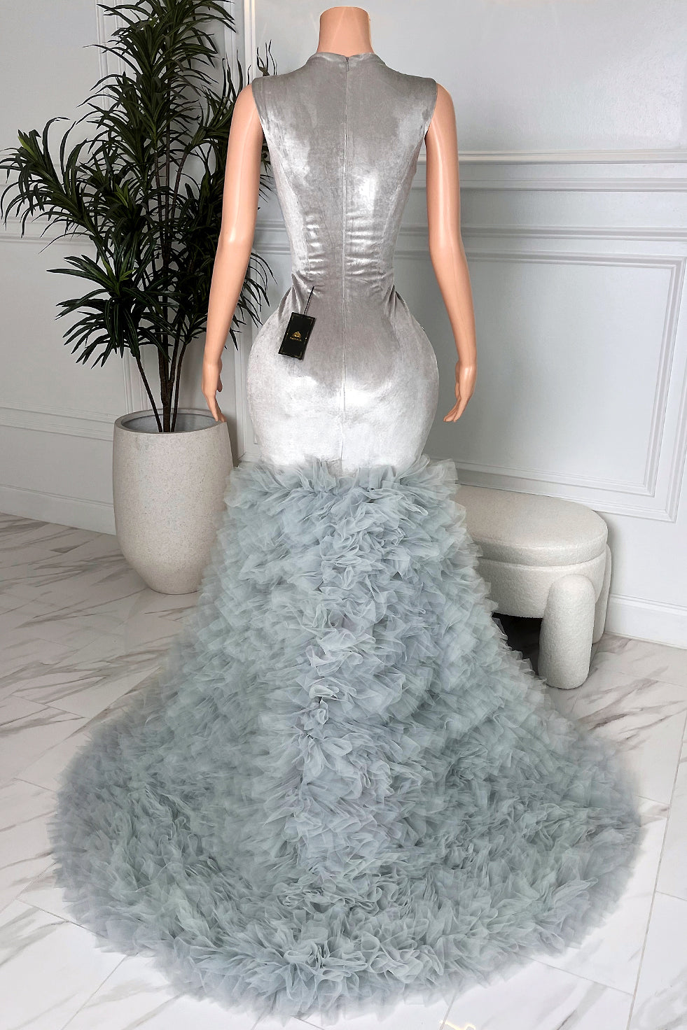 Back view of silver floor-length mermaid gown with fitted satin-look body and layered grey tulle ruffle train formal dress