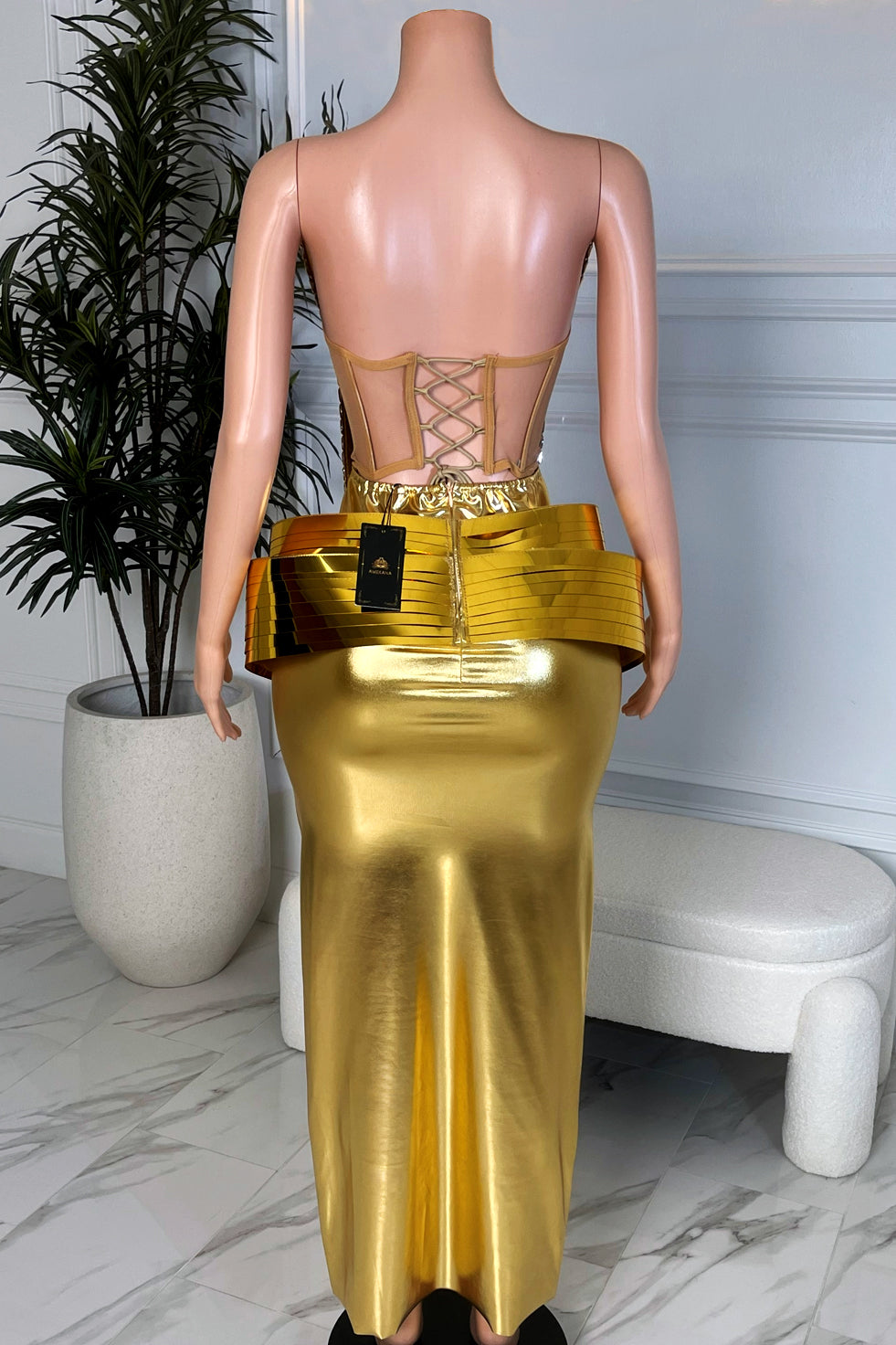 Back view of gold chrome corset skirt set with nude lace up back and smooth gold midi skirt.