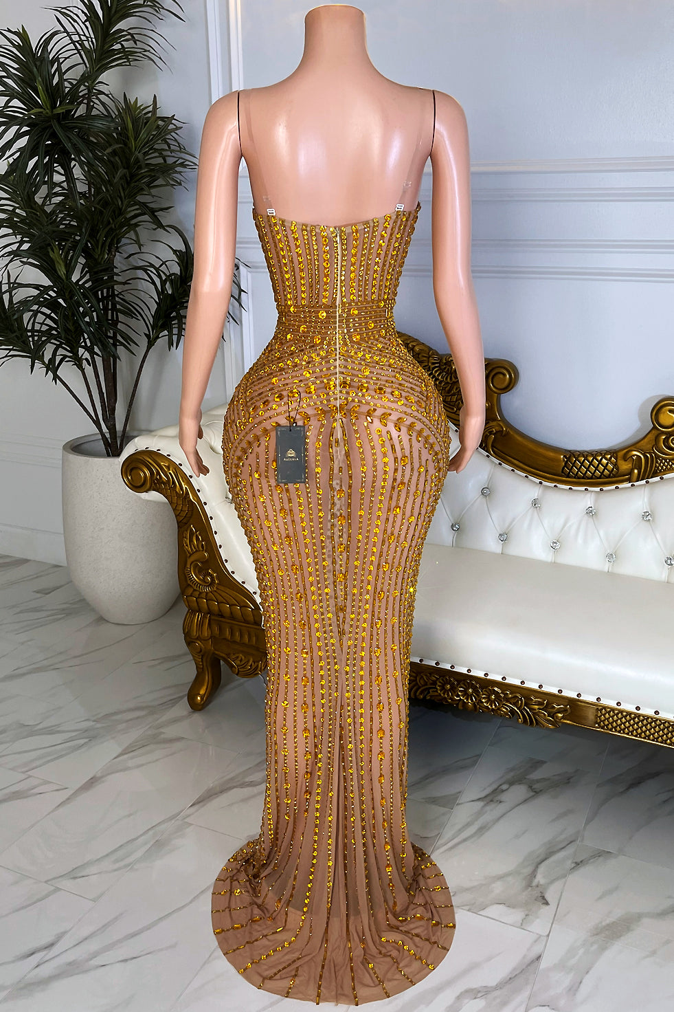 Back view of gold rhinestone bodycon maxi dress featuring nude illusion mesh, fitted silhouette, and subtle train