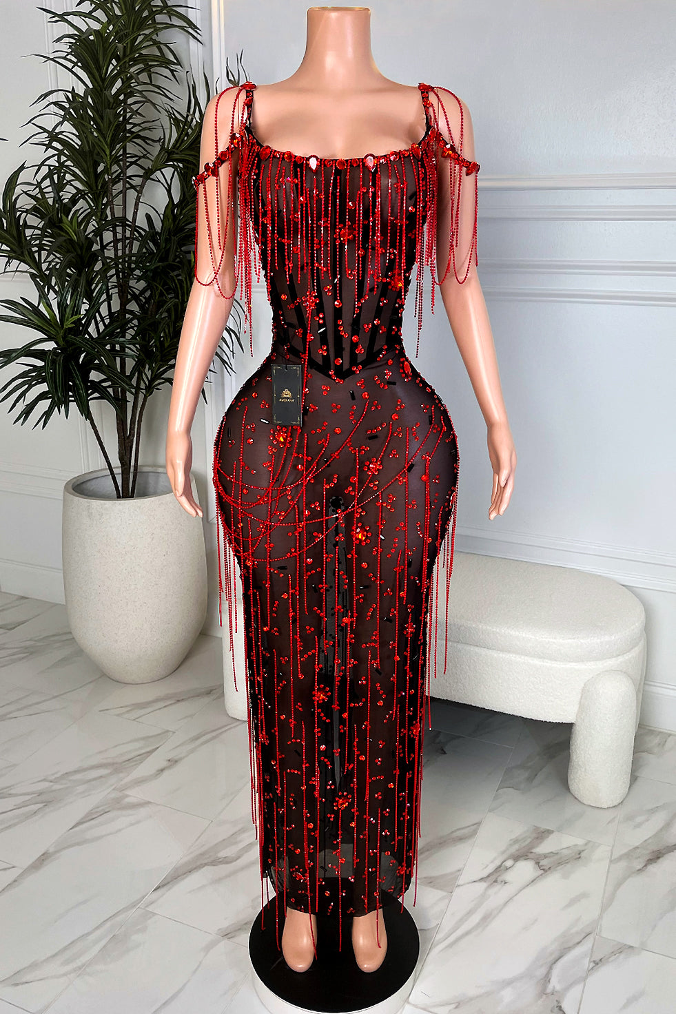 Black sheer mesh maxi dress with red rhinestone embellishments, beaded tassel fringe, and off-shoulder drape straps front view