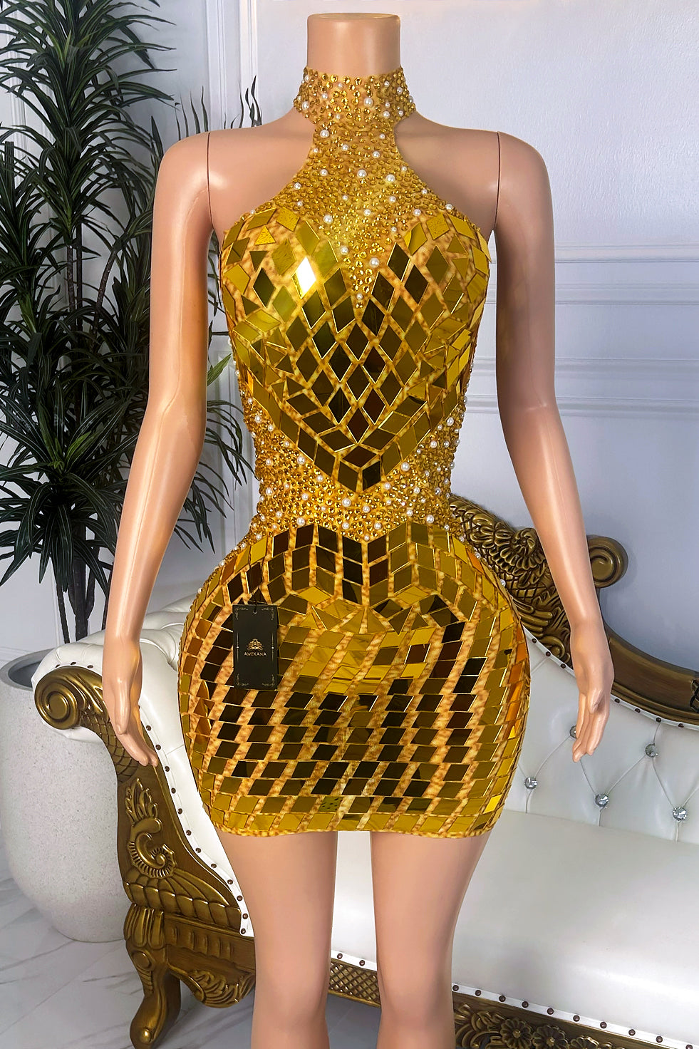 Front view of a gold high neck mini dress with mirror-style geometric embellishments, rhinestone accents, pearl-like details, and fitted bodycon silhouette.