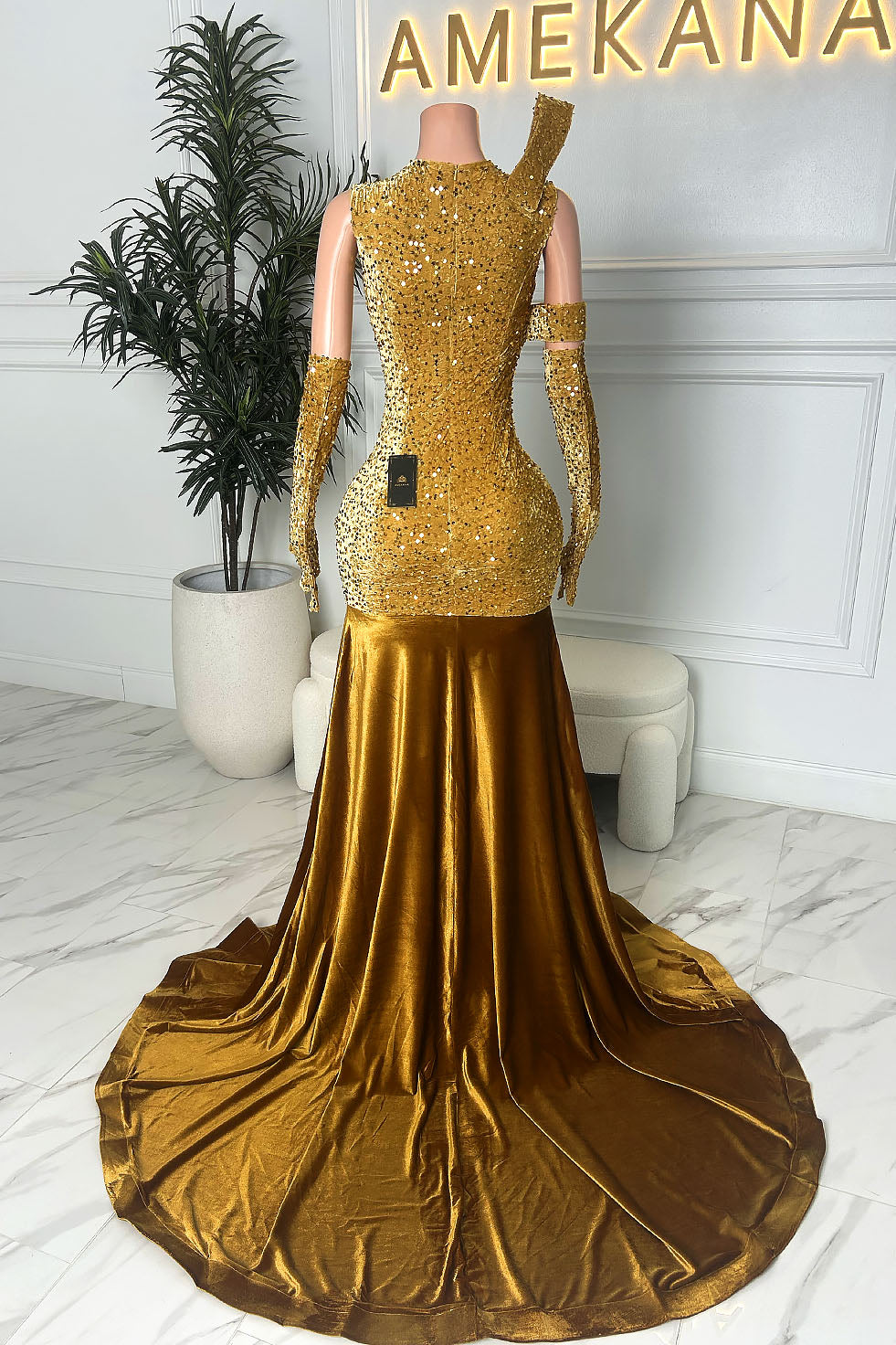 Front view of a gold illusion gown with embellished bodice, deep plunge detail, one-shoulder accent, matching gloves, and metallic mermaid skirt