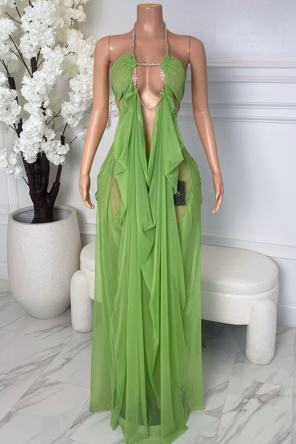 Front view of green sheer maxi dress with crystal chain neckline, deep open front, gathered bust, and flowing draped fabric