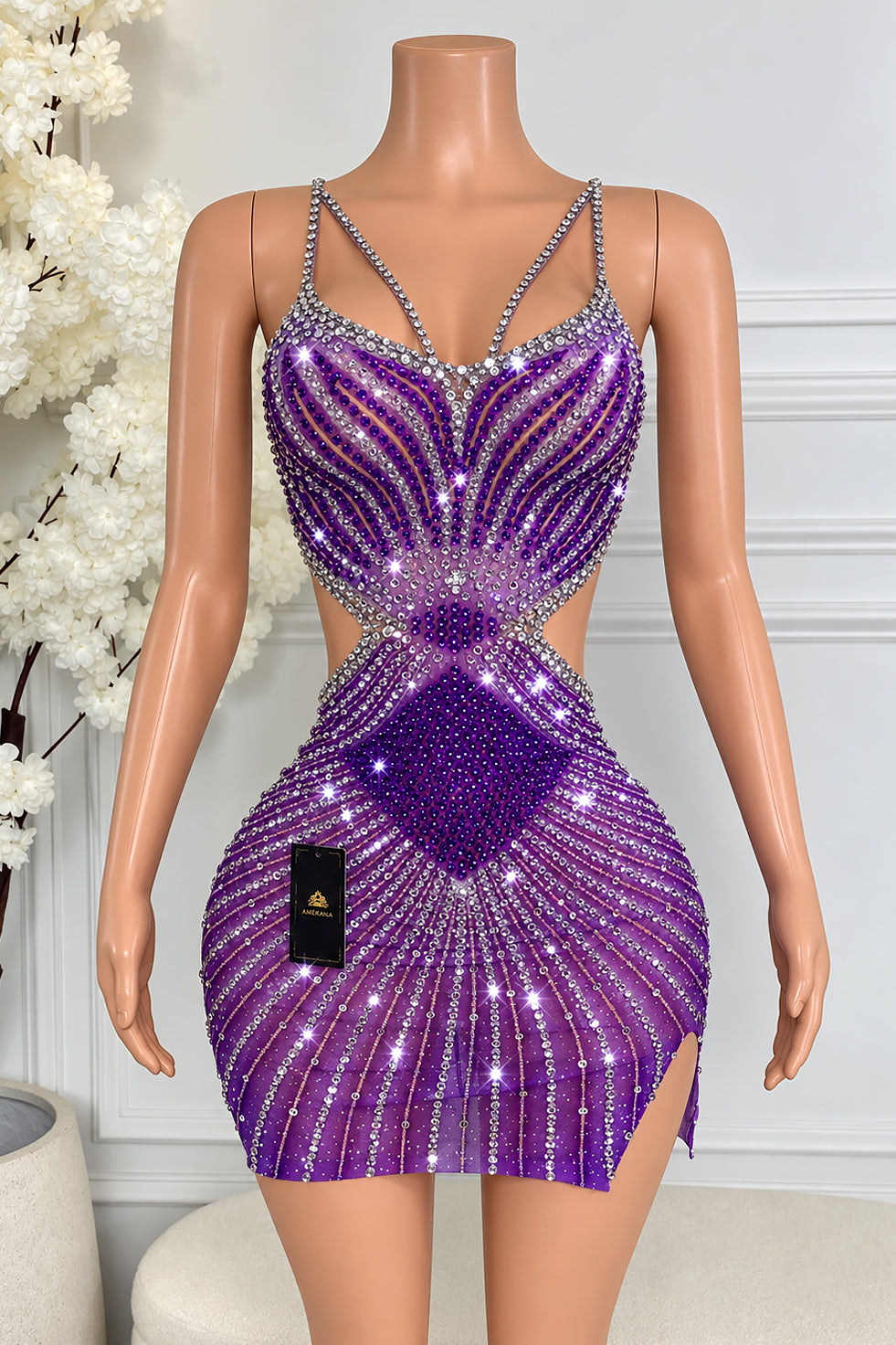 Amekana June Purple Rhinestone Mini Dress featuring sparkling purple and silver rhinestones, a plunging neckline, rhinestone straps, dramatic waist cutouts, and a fitted silhouette with a thigh slit.