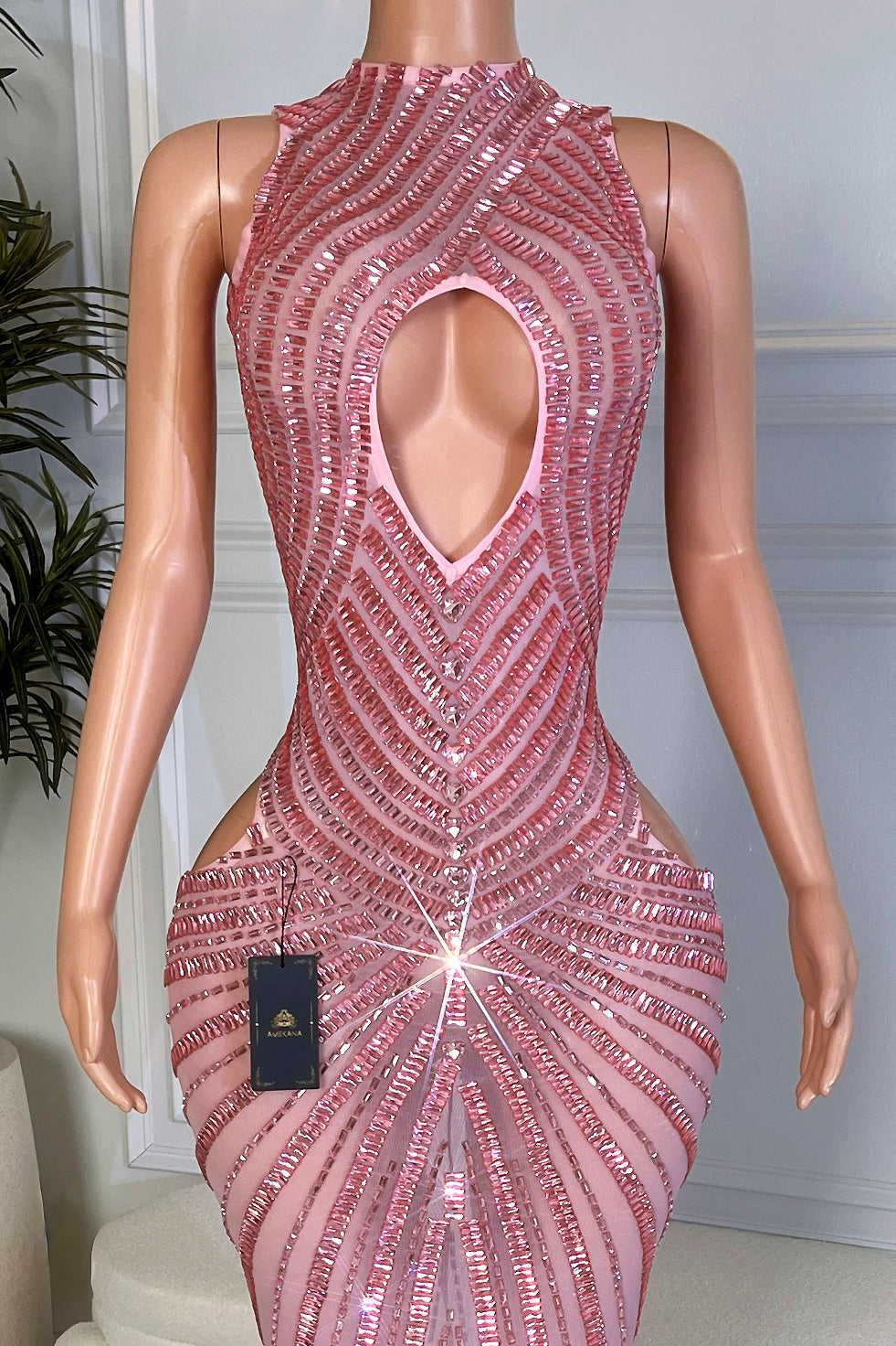 Close up of the bodice of the pink sequin maxi dress showing the oval keyhole cutout and detailed pink sequin pattern.