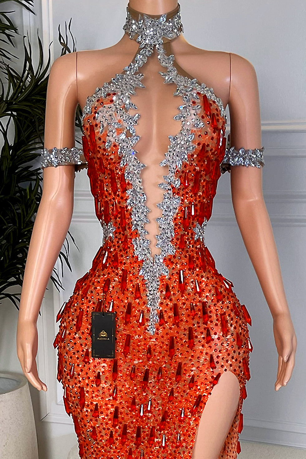 Close up of Amekana Ember Royalty gown bodice with deep illusion plunge, silver crystal neckline and dense red rhinestone embellishments.