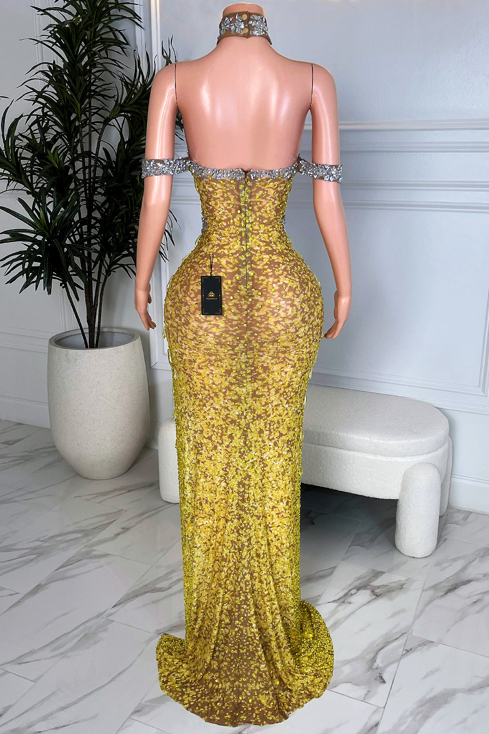 Back view of Krystal yellow rhinestone side slit maxi dress featuring silver crystal choker neckline detail, open illusion back design, and fitted floor-length silhouette.