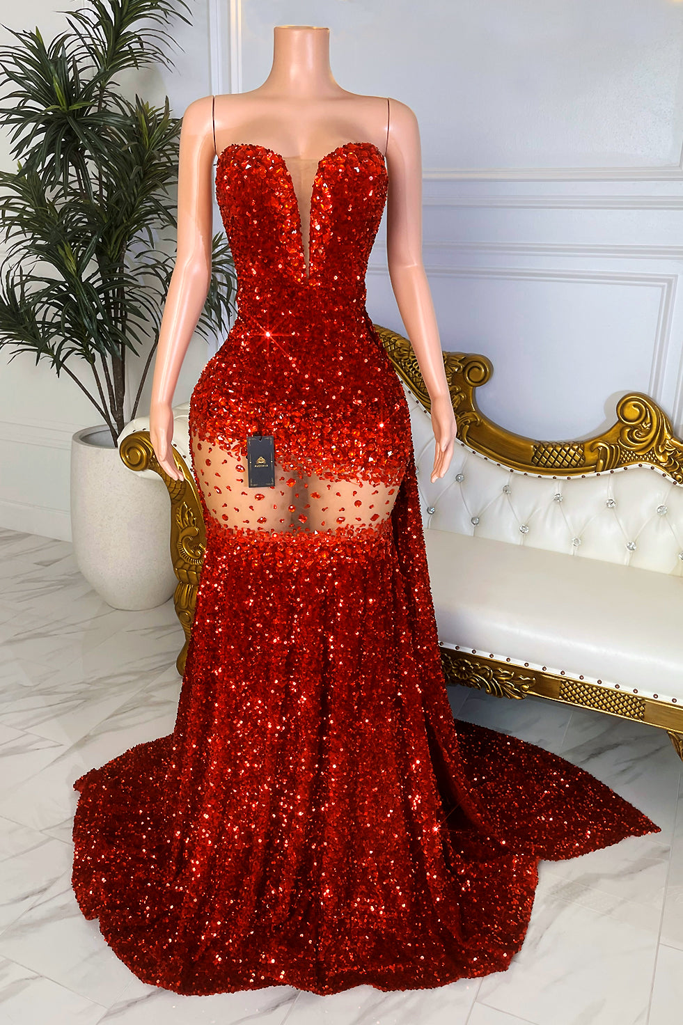 Back view of sparkly red sequin mermaid gown with sheer waist detail and dramatic floor length train