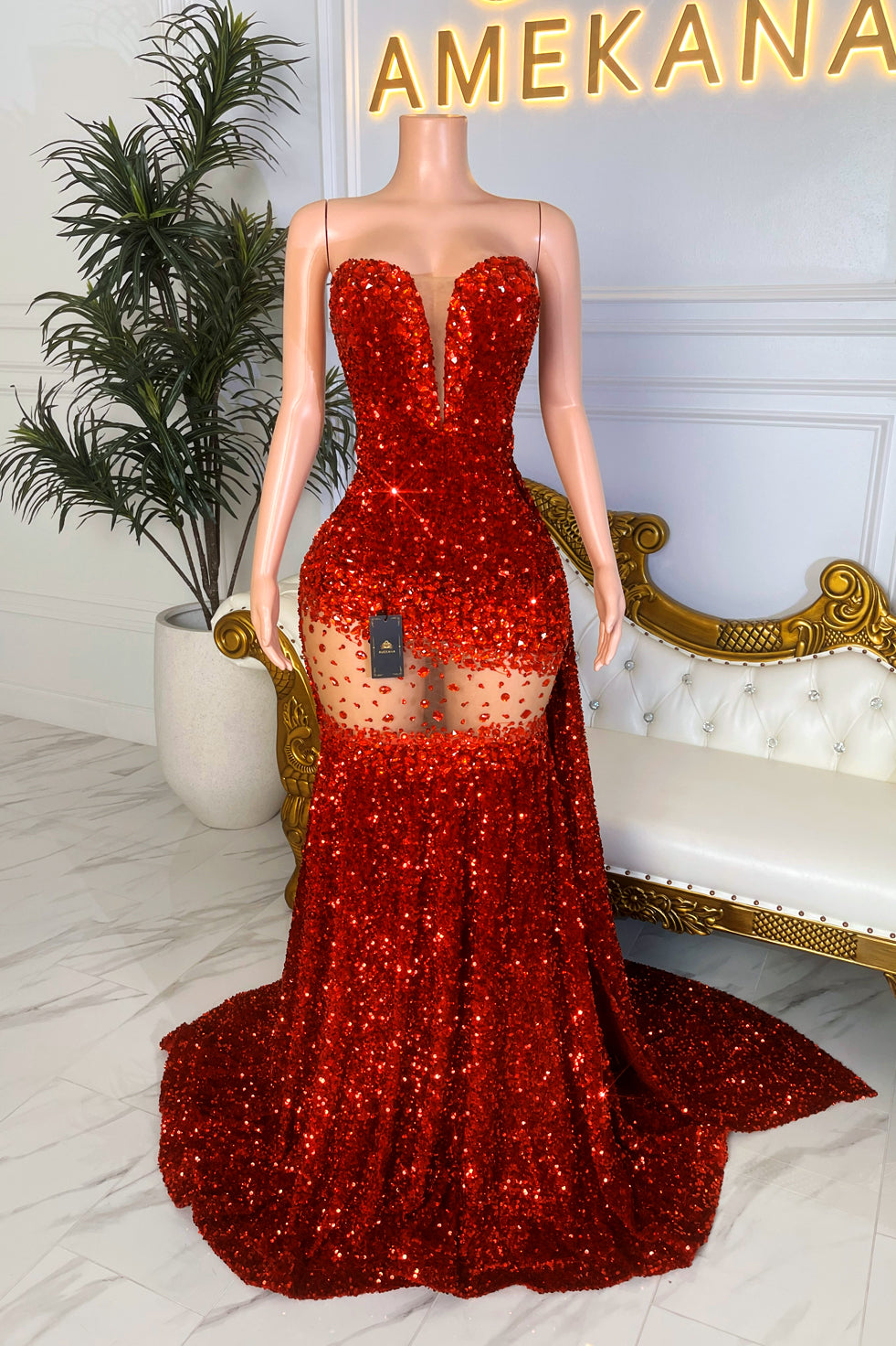 Model in strapless red sequin mermaid gown with sheer rhinestone waist cutout and long train, Amekana