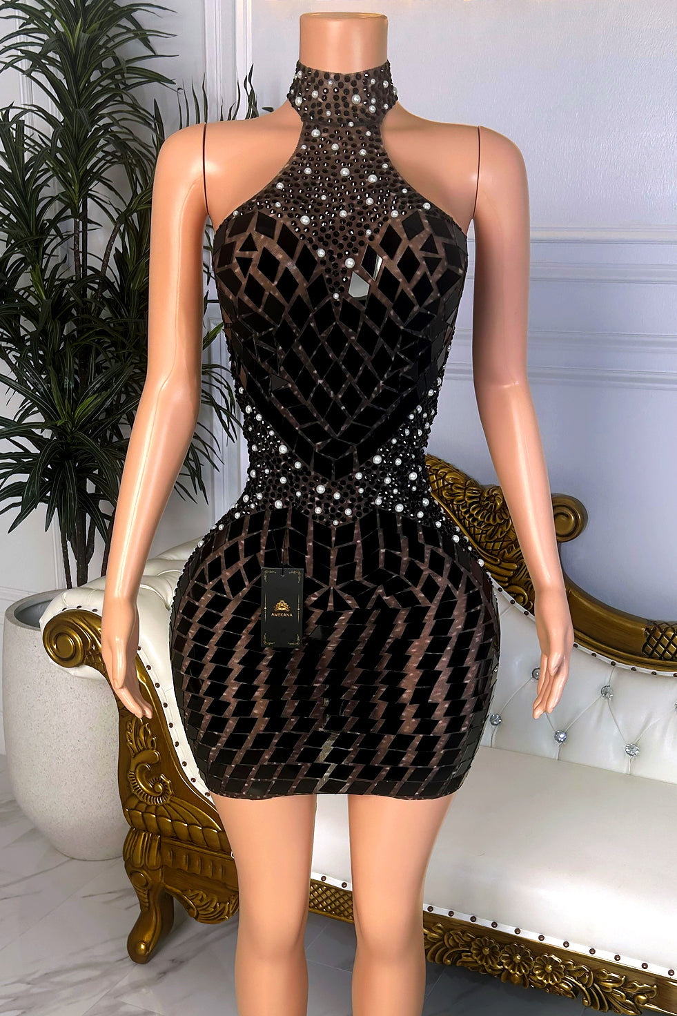 Front view of a black high neck mini dress with sheer rhinestone mesh, pearl-like accents, geometric mirror embellishments, and fitted silhouette.