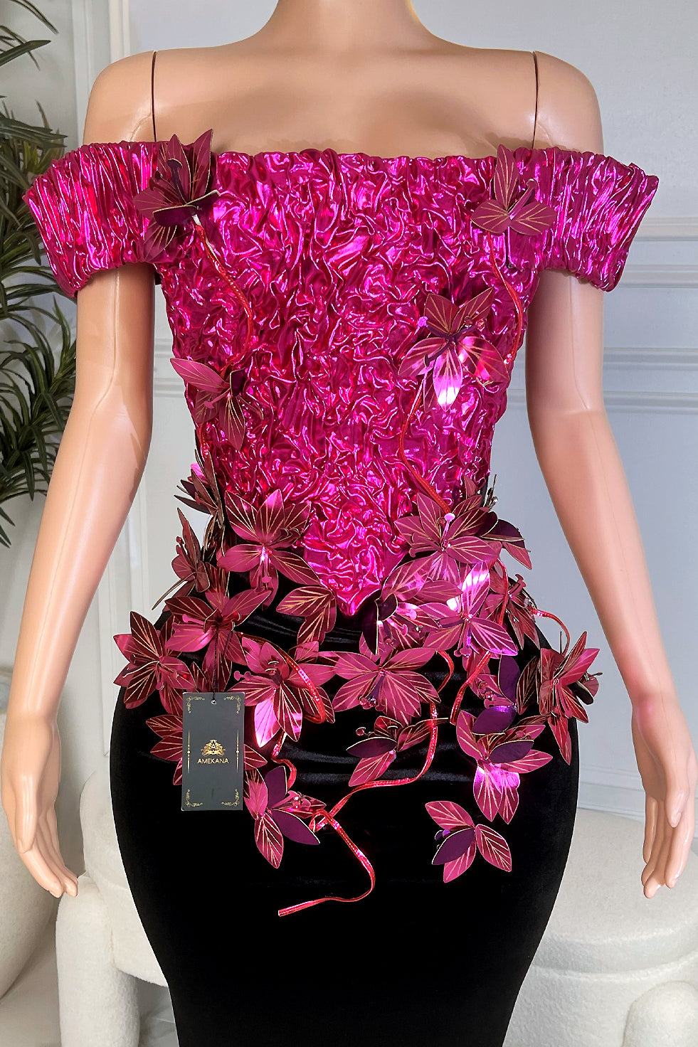 Close up of hot pink crinkled metallic off shoulder bodice with 3D floral vine appliqués over black velvet waist.