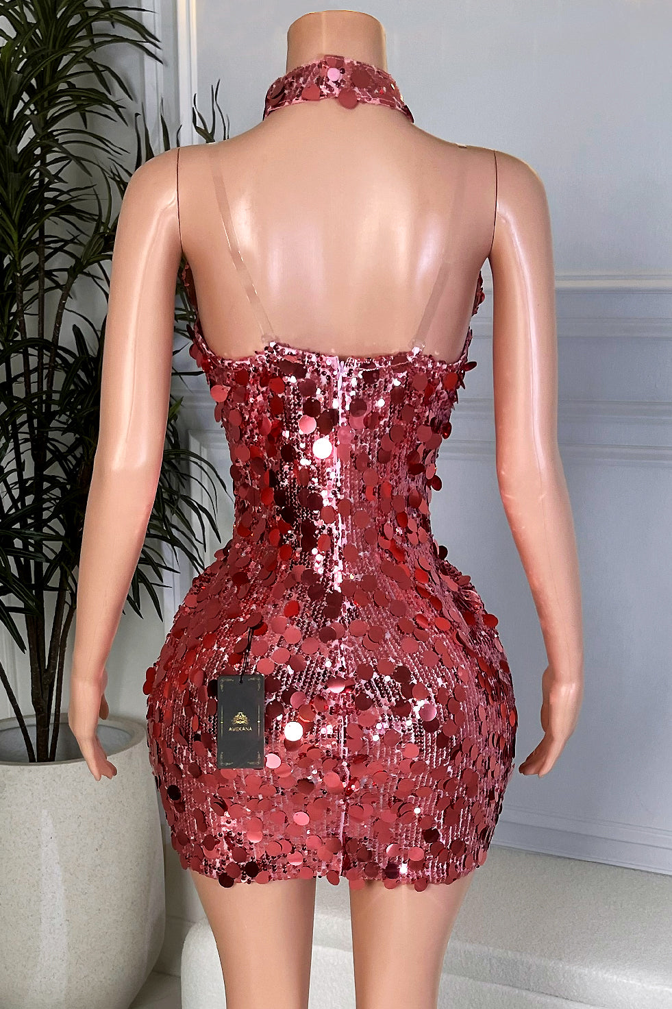 Back view of rose pink sequin mini dress with choker neckline, fitted silhouette, and shimmering oversized pink sequins