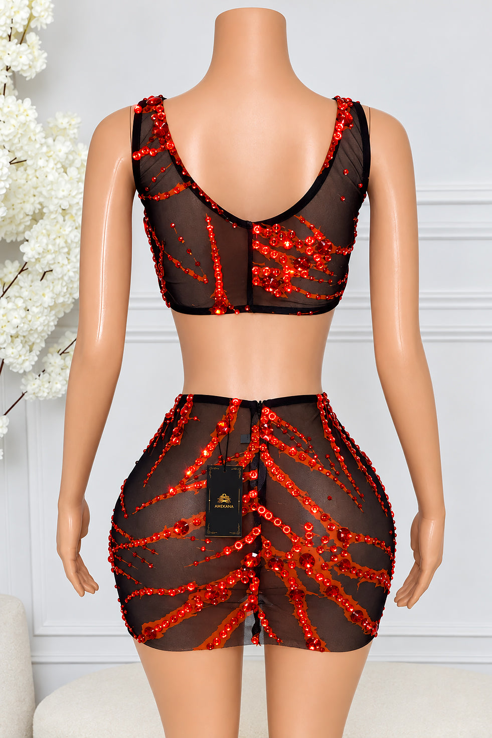 Back view of Ravessa black mesh two piece skirt set with V neckline and red rhinestone patterns