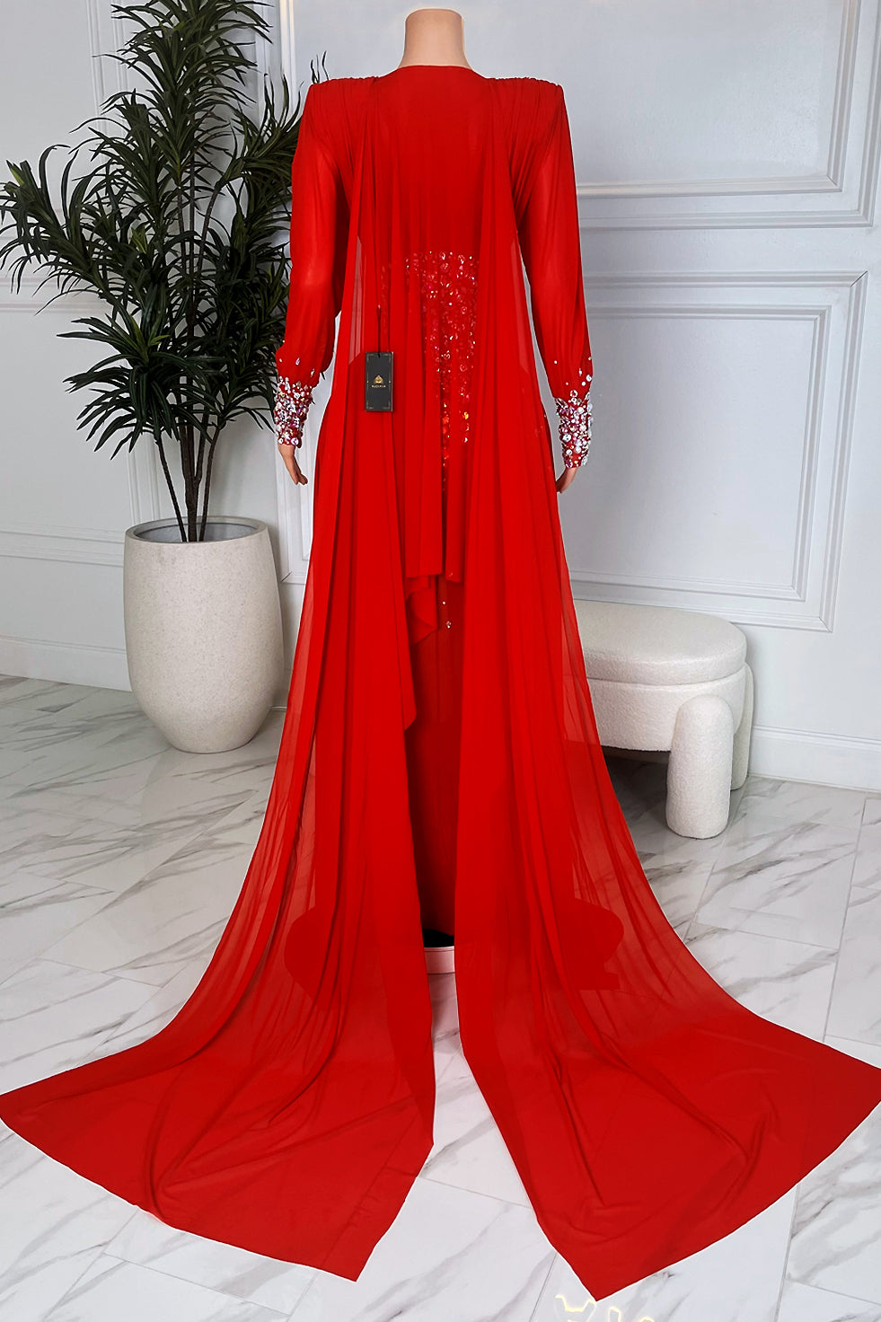 Back view of red rhinestone embellished maxi dress with flowing chiffon cape style train”