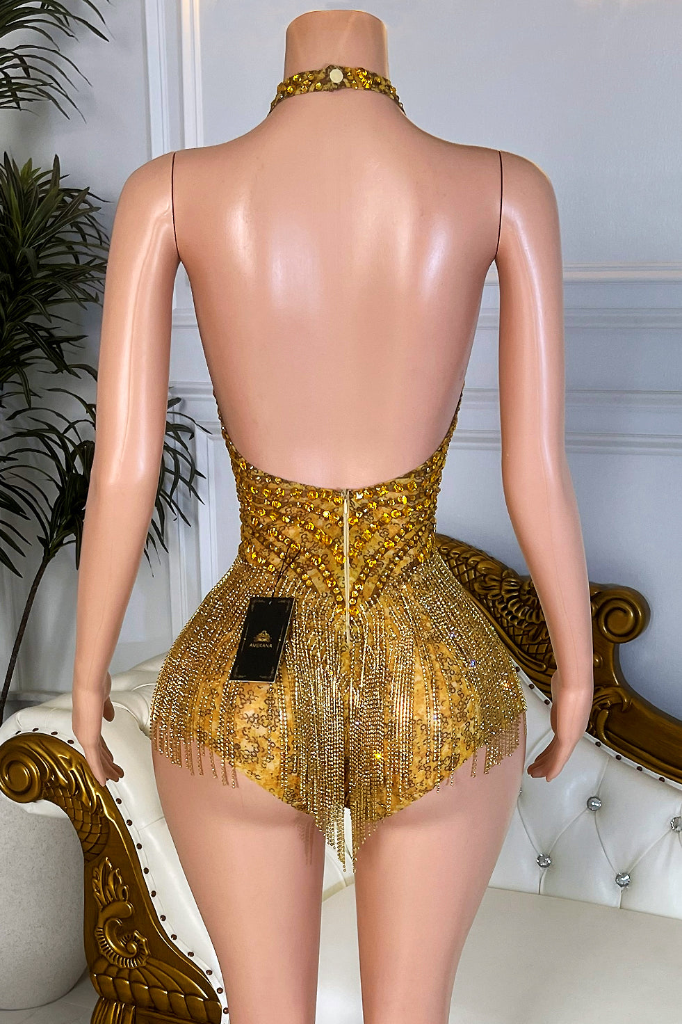 Gold rhinestone tassel romper playsuit with open low back and fringe hem on nude mesh mannequin back view