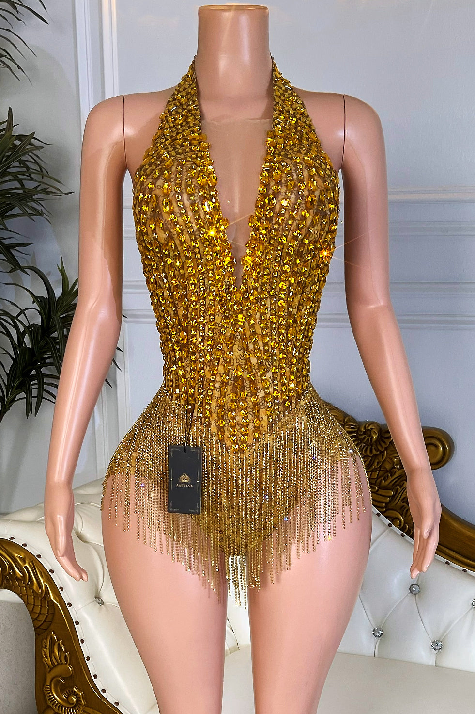 Gold rhinestone tassel romper playsuit with deep halter neckline on nude mesh mannequin front view