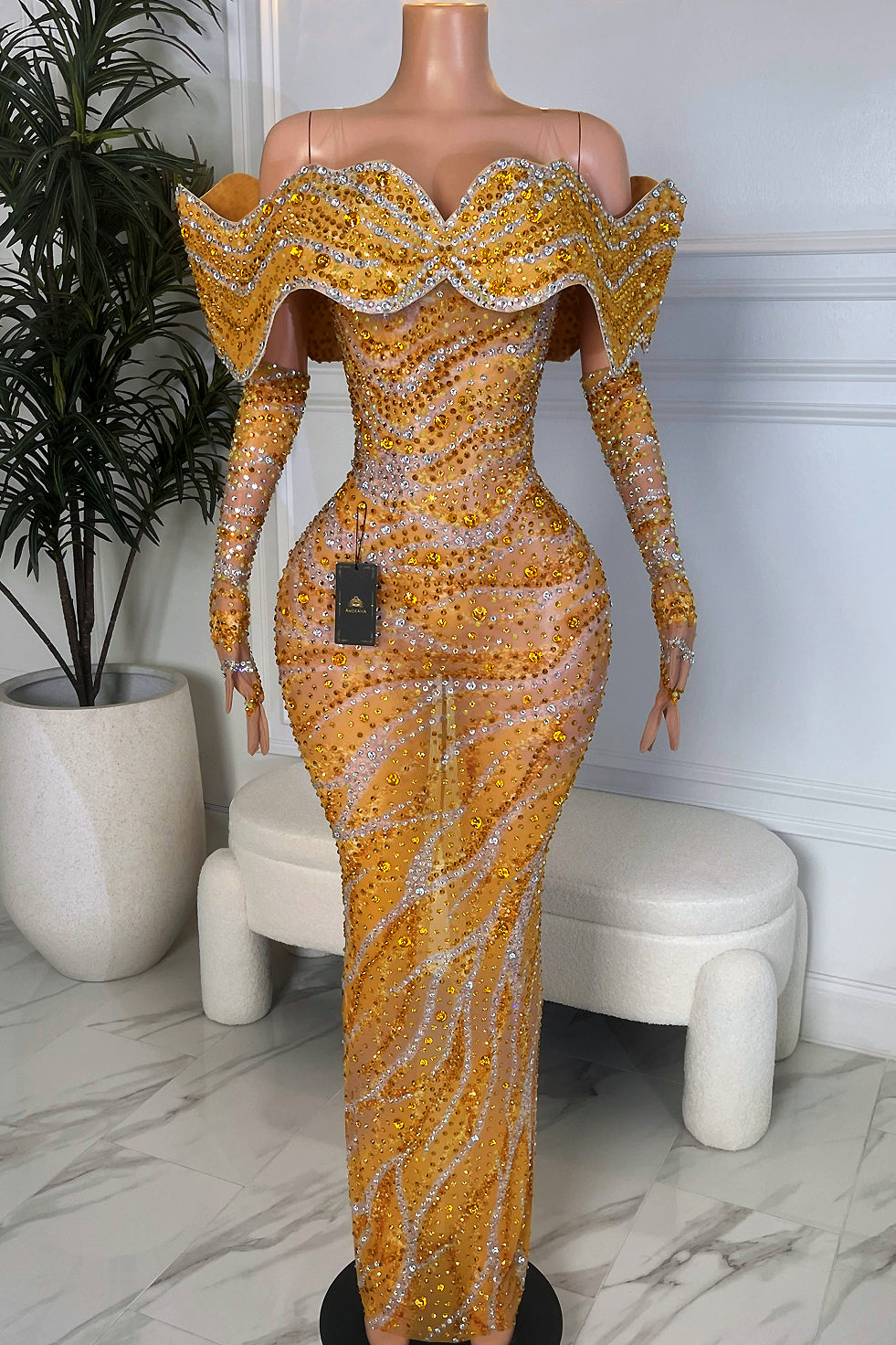 Front view of sparkly yellow off shoulder rhinestone mesh evening gown on mannequin.