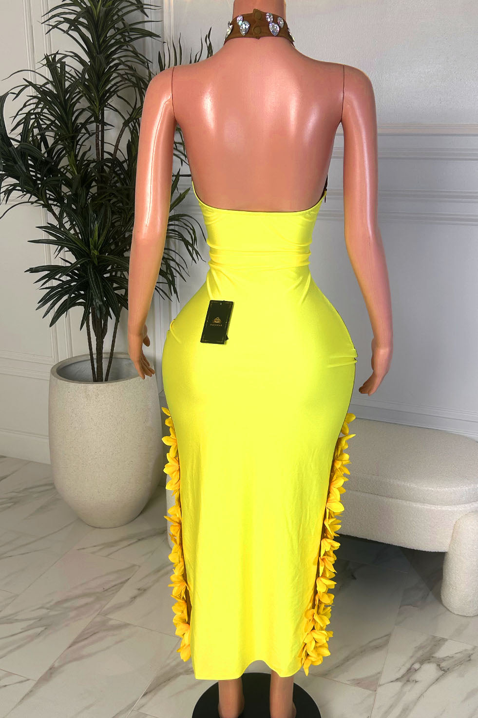 Back view of yellow fitted gown with crystal halter neckline and floral detailing along the slit edge